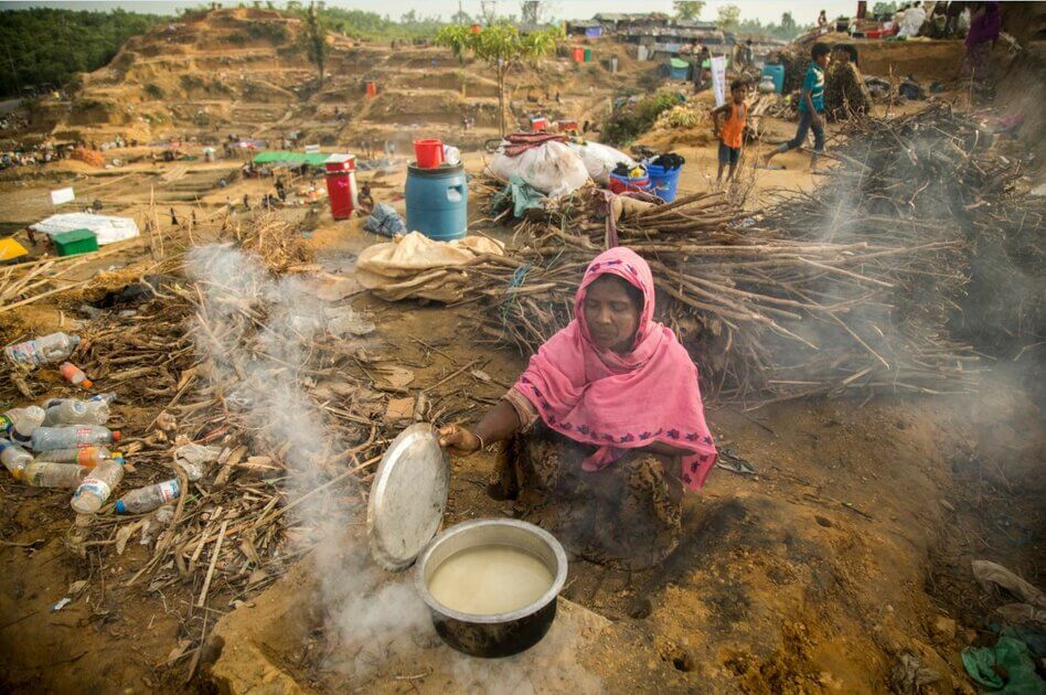  Mahmuda prepares a meagre meal for her family in the makeshift shelter she built on a Bangladeshi hilltop, as she tells us about her escape from Myanmar